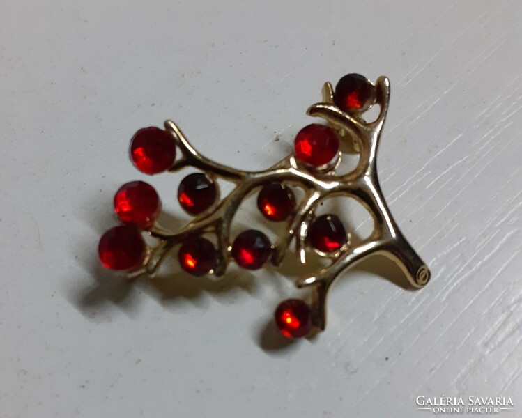 Old brooch badge studded with red stones