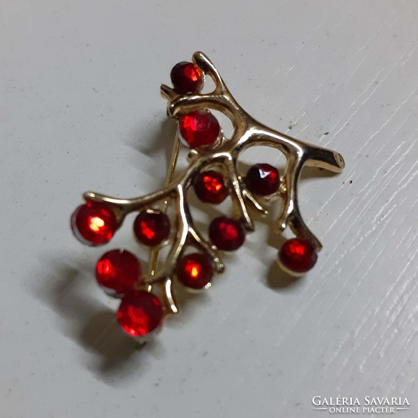 Old brooch badge studded with red stones