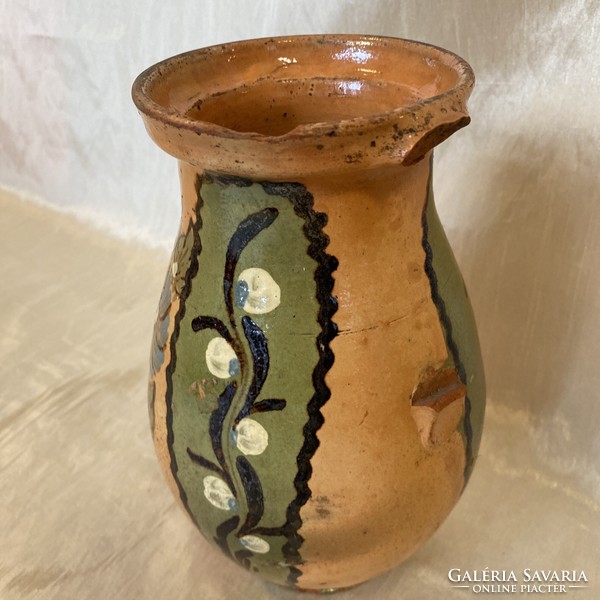 A folk ceramic mug with a flower pattern