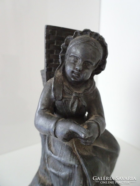 Resting vintage little girl detail with rich tin sculpture.
