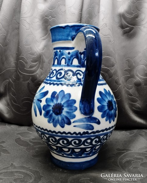Glazed blue ceramic jug with flowers