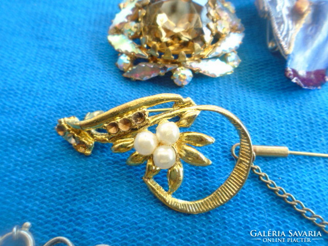 A large handful of mixed jewelry 7 brooches an armlet a bracelet three pendants a clip a ring