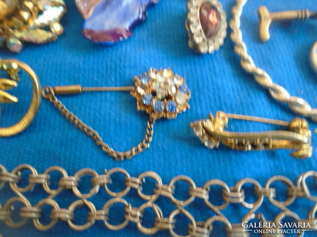 A large handful of mixed jewelry 7 brooches an armlet a bracelet three pendants a clip a ring