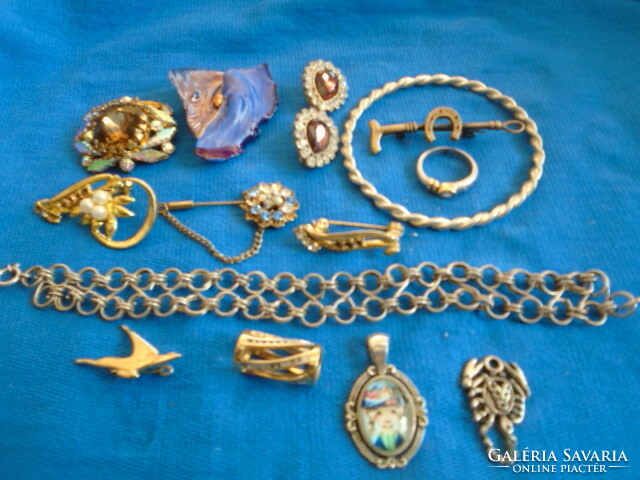 A large handful of mixed jewelry 7 brooches an armlet a bracelet three pendants a clip a ring