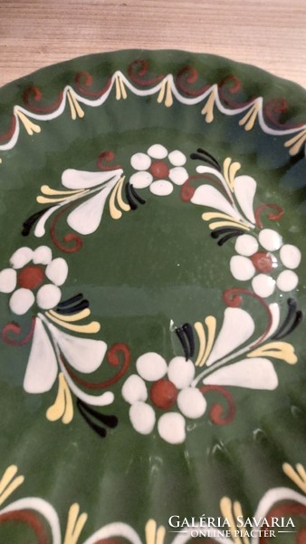Ceramic wall decoration with white flowers on a green background marked J9, wall plate diameter 19 cm