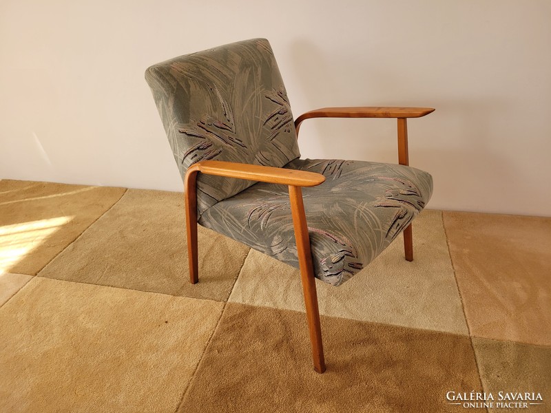Retro old mid-century armchair with wooden arms