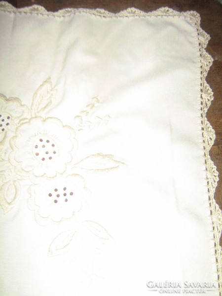 Beautiful crocheted tablecloth with beige flowers on a beige background