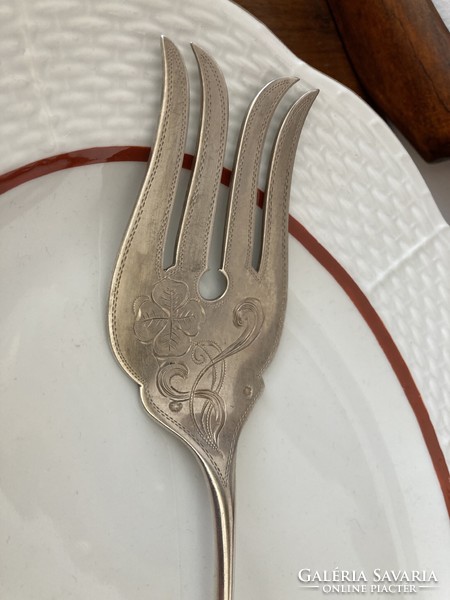 Silver fish serving knife and fork, with a chiseled, decorative head