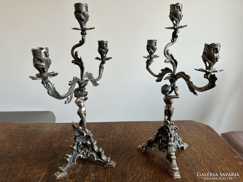 Pair of silver, figured, marked, three-pronged candlesticks