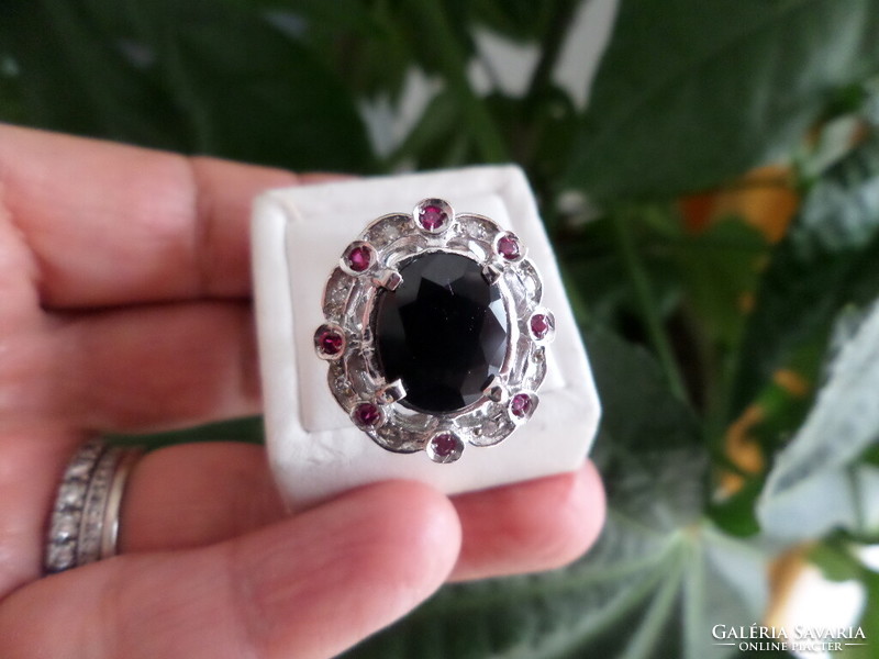 White gold ring with dark blue sapphire, brilles and synthetic ruby