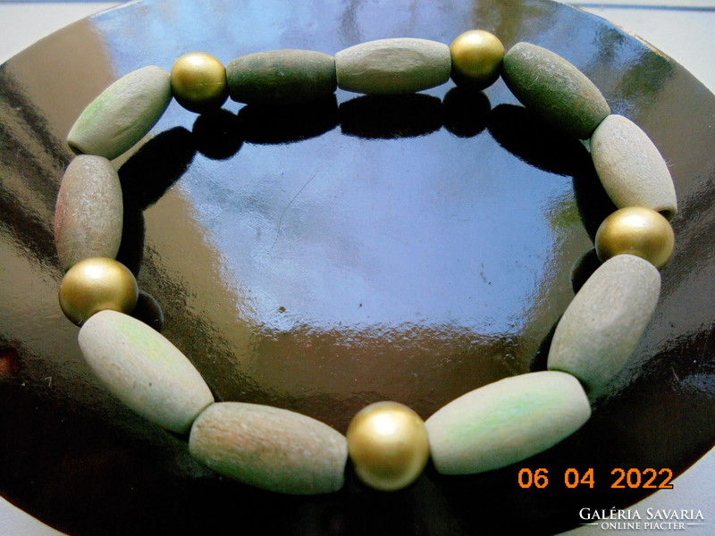 Bracelet made of beige, greenish and gold colored wooden beads