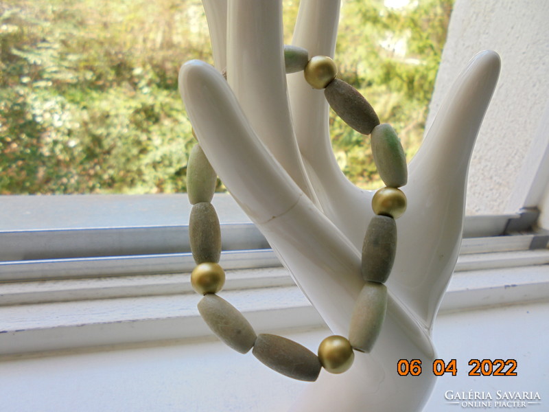 Bracelet made of beige, greenish and gold colored wooden beads