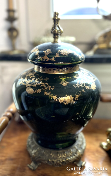 A gilded glass vase with a lid on a bronze base and with tongs