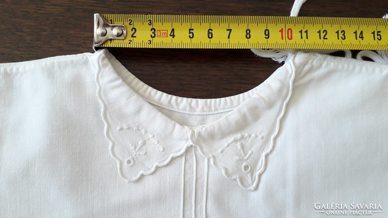 Old shabby baby clothes in traditional costume embroidered on canvas babaing