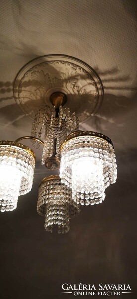 Polished crystal chandelier, three parts, with original pendants and decorations.