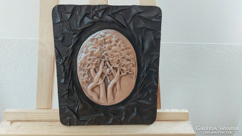 (K) marked ceramic wall decoration, in a leather frame