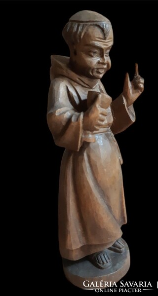 Old Spanish wooden statue of a wine-drinking monk