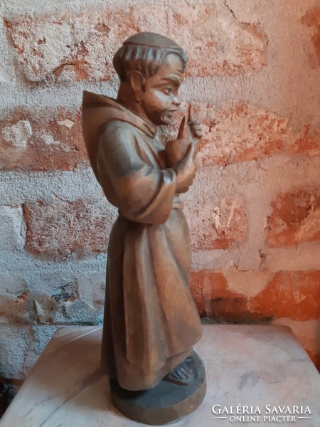 Old Spanish wooden statue of a wine-drinking monk