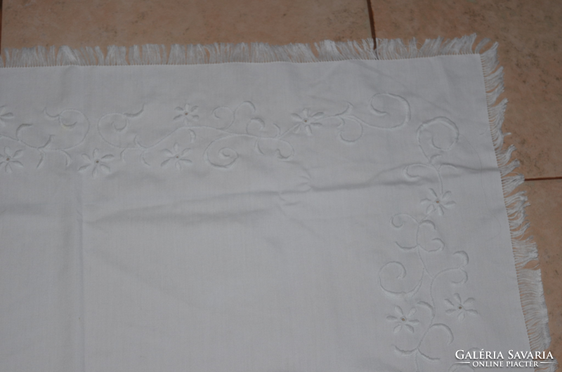Center table with white embroidery on a white background
