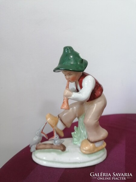 Old German porcelain figure, boy playing the flute