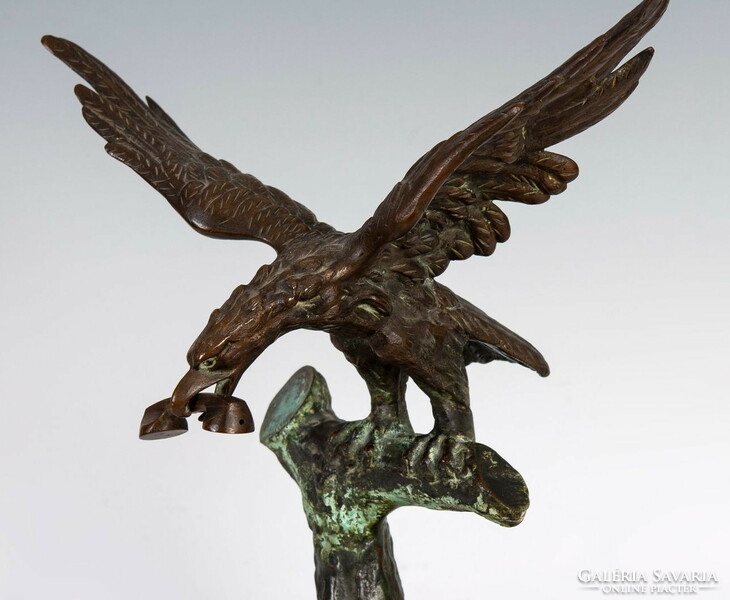 Bronze statue of an eagle with a telephone in its beak