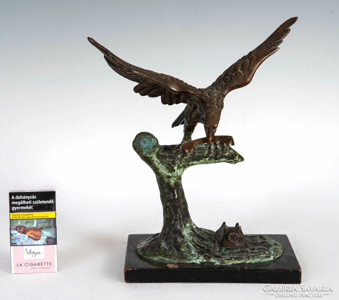 Bronze statue of an eagle with a telephone in its beak