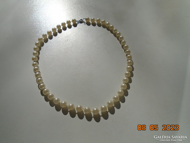 Older necklace made of individually knotted white pearls with silver-plated clasp