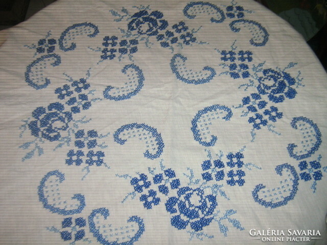 A beautiful cross-stitch blue rose pattern round tablecloth with a slinged edge