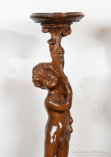 Carved wooden pedestal with a child figure