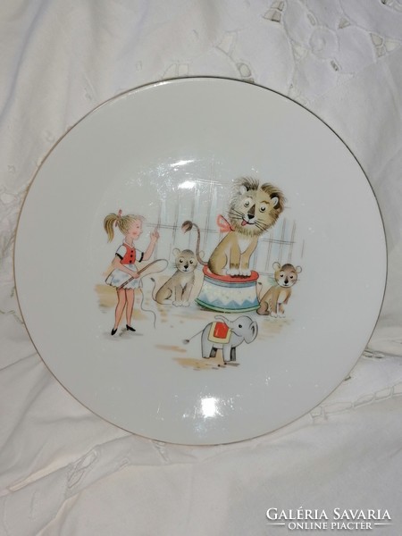 A story plate with a lion tamer, a lion, and a circus