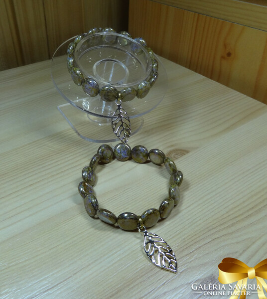 Lens-shaped bracelet made of white - gold colored pearls 14 kt. Beautiful golden leaf decoration.