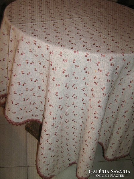 A beautiful and elegant cherry colored tablecloth with a lace edge