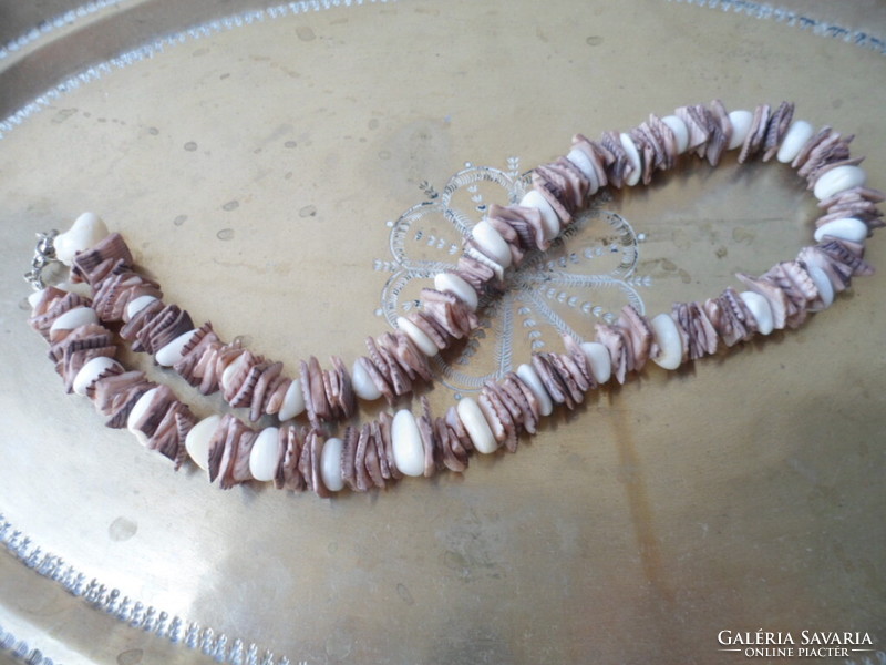 A necklace or bracelet made of small pieces of polished seashells