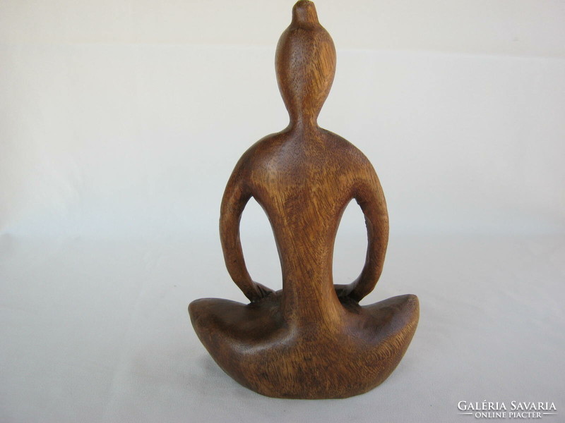 Carved wooden sculpture of a girl doing yoga