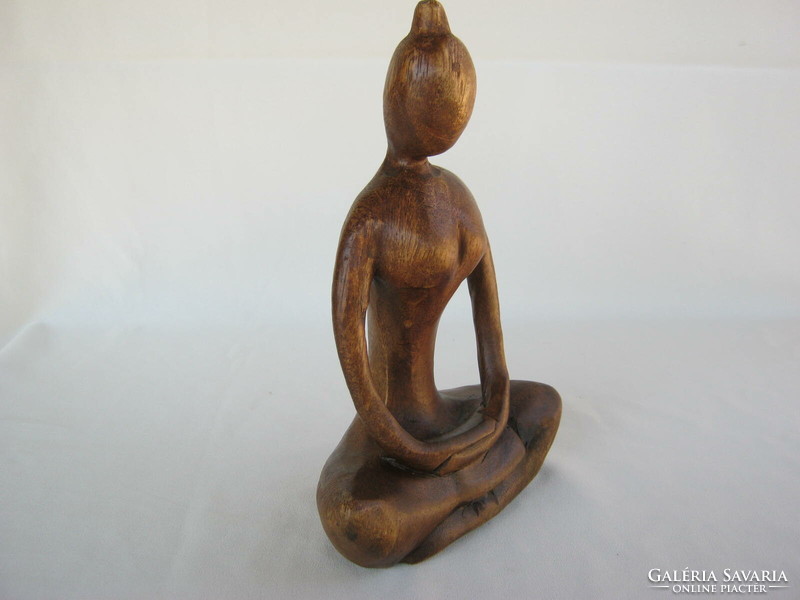 Carved wooden sculpture of a girl doing yoga