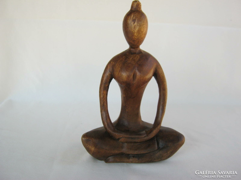 Carved wooden sculpture of a girl doing yoga