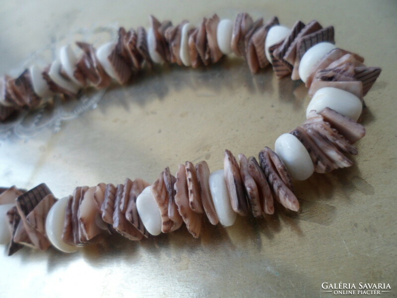 A necklace or bracelet made of small pieces of polished seashells