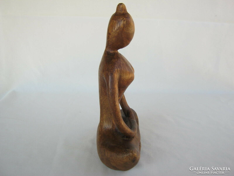 Carved wooden sculpture of a girl doing yoga