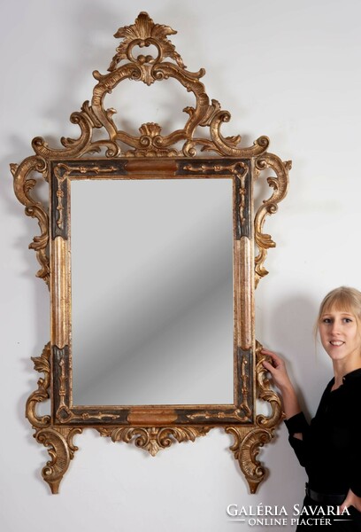 Carved wooden framed mirror with top decoration