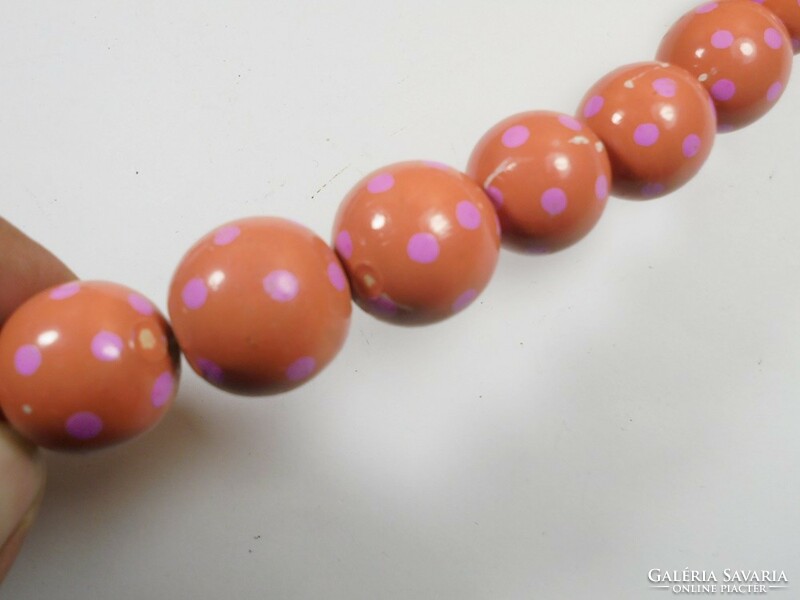 Old retro pink polka dot red necklace made of painted wooden eyes of different sizes
