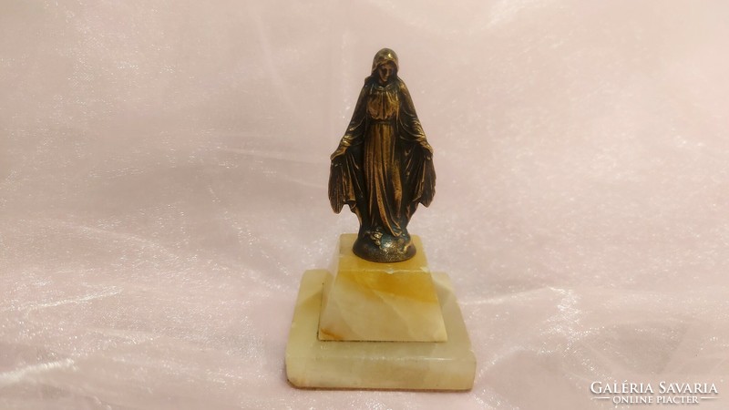 Old copper statue of the Virgin Mary on a marble plinth