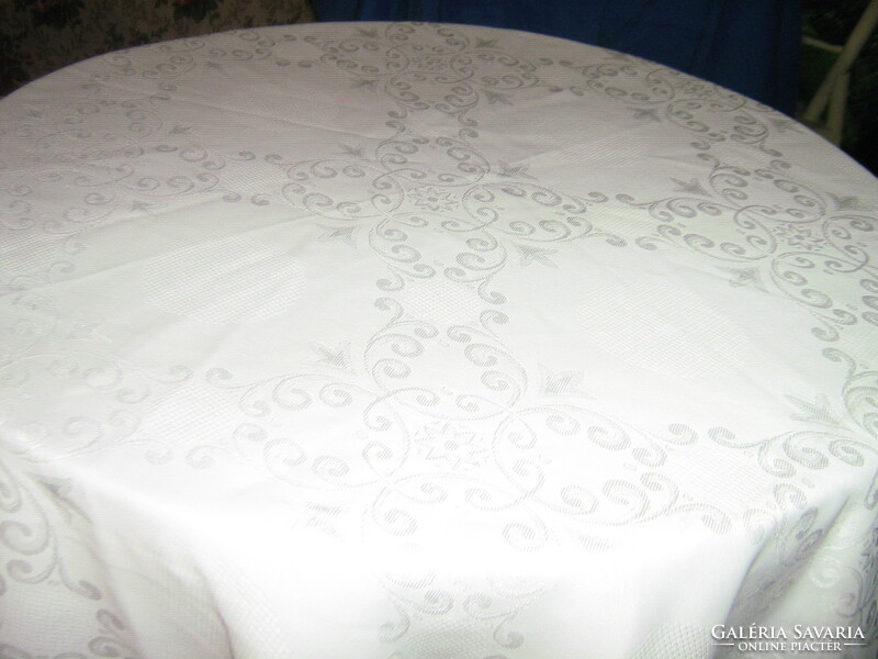 Beautiful round white silk damask tablecloth with a baroque pattern with a lace edge