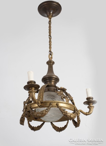 Three-armed bronze chandelier with a polished shade in the middle