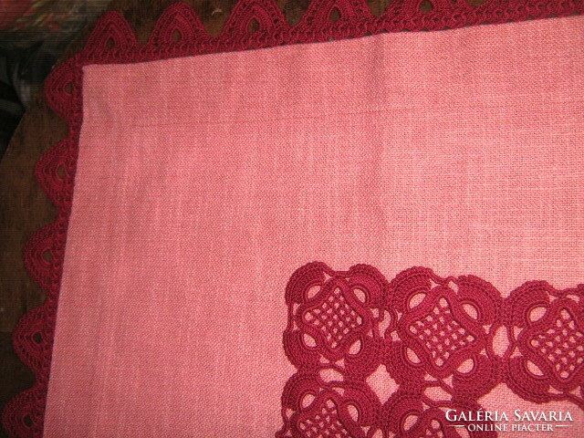 A beautiful and elegant mauve-burgundy woven tablecloth with a hand-crocheted edge and decorated with crochet