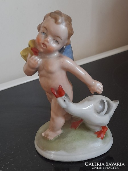 Charming old porcelain figurine of a boy with a goose