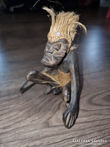 African wooden statue of a man on a shield