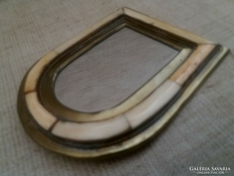 A small wall-hanging mirror with a brass bone inlay frame