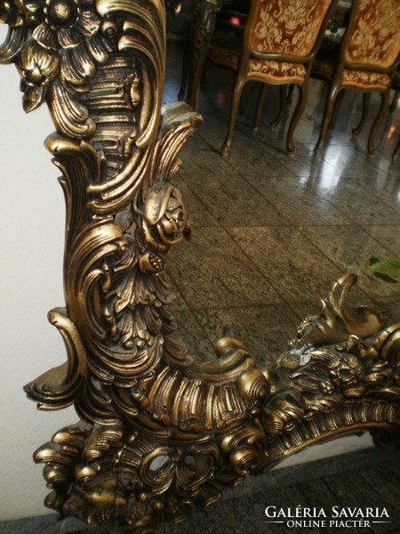 Hand-carved gold-colored, baroque-style mirror decorated with an angel figure and other motifs