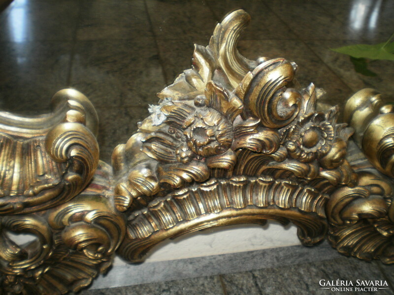 Hand-carved gold-colored, baroque-style mirror decorated with an angel figure and other motifs