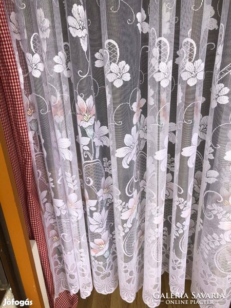 Translucent curtain with a flower pattern on a white background, with a colorful motif at the bottom